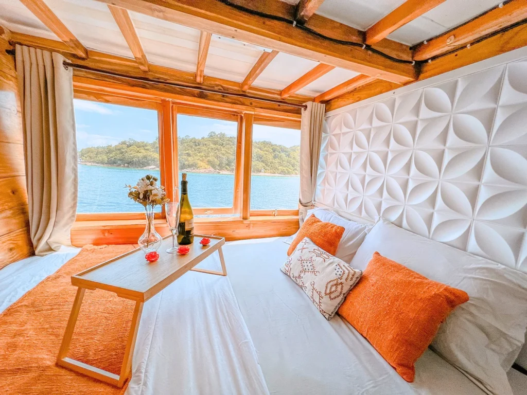 Wooden sea-view cabin interior aboard Akassa phinisi