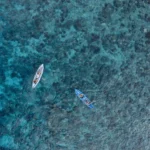 Aerial view of guests kayaking and paddleboarding near Aliikai Voyage
