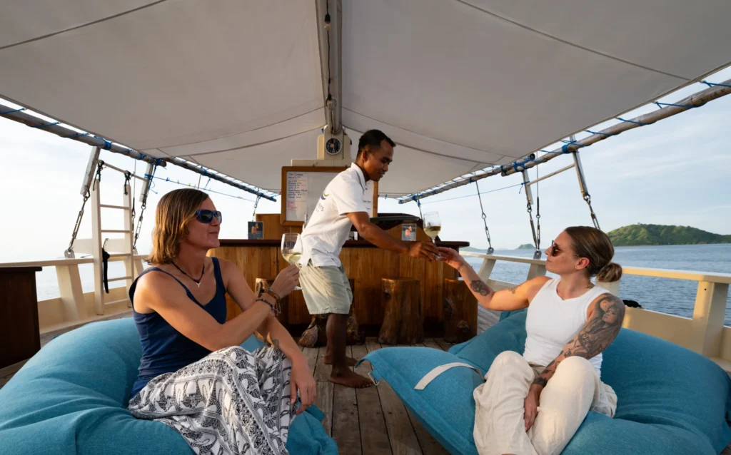 Guests relaxing in the shaded outdoor lounge aboard EcoPro Duyung Baru