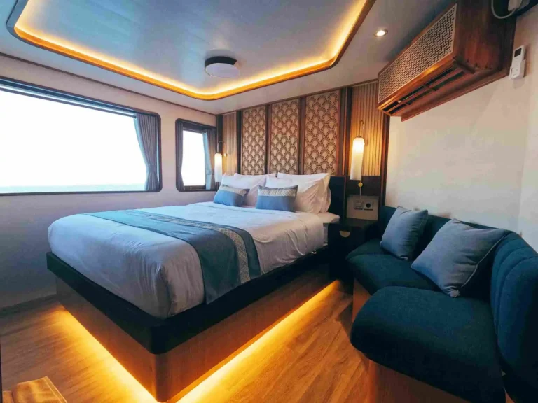Signature cabin aboard Nayara Cruise with double bed and lounge seating