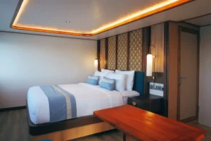 Suite cabin aboard Nayara Cruise with double bed and sea-view windows