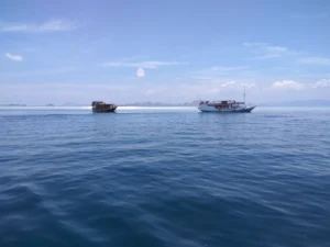 Visitors walking the narrow strip of sand at Taka Makassar