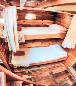 Wooden bunk beds in a shared cabin aboard Bajak