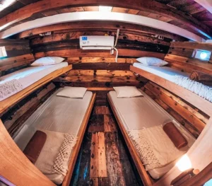 Shared sleeping cabin with twin-style beds aboard Bajak