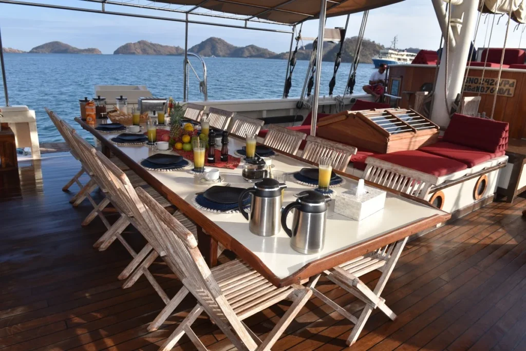 Outdoor dining area on the teak deck of Emperor Raja Laut