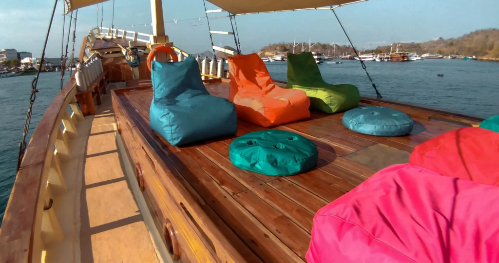 Partially shaded sun deck with colorful loungers aboard Lalunia