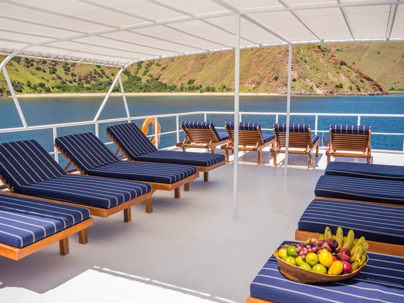 Shaded sun deck with cushioned loungers aboard MV Mermaid I